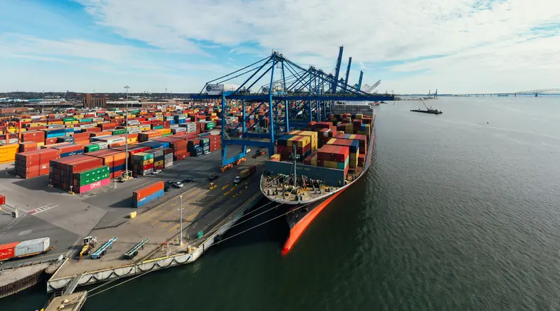 Vue aérienne d'un terminal à conteneurs, portiques bleus et navire à quai