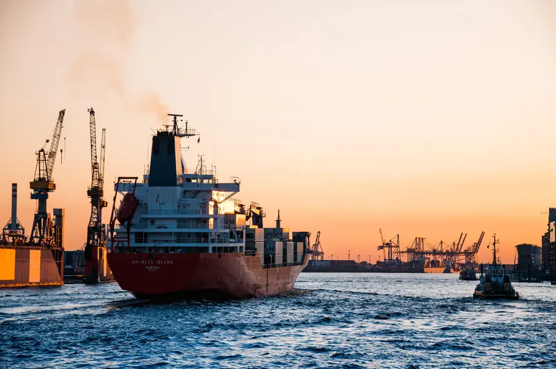 Navire au port au coucher du soleil, grues en contre-jour